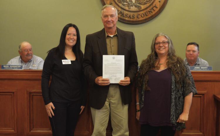 Lampasas County Judge Randy Hoyer (center) holds the proclamation that declared Thursday as Go Purple Day in Lampasas County. He is joined by Kaylene Vaughn (left) and Amber Balusek of the Highland Lakes Family Crisis Center. ERICK MITCHELL | DISPATCH RECORD