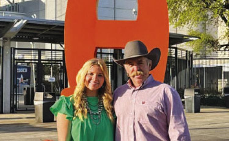 Kari Greiner is shown with her father, Corey, at a major show. Greiner competed in San Antonio, Houston and Fort Worth in each of the three years she showed animals. COURTESY PHOTO