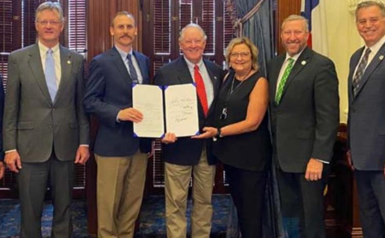 Present for the governor’s June 4 signing of an updated farm animal liability bill are, from left, Rep. DeWayne Burns, Rep. Glenn Rogers, Rep. Andrew Murr, Mickey and Jani Edwards of Lampasas, Sen. Drew Springer, Rep. David Spiller and Rep. Doc Anderson. COURTESY PHOTO