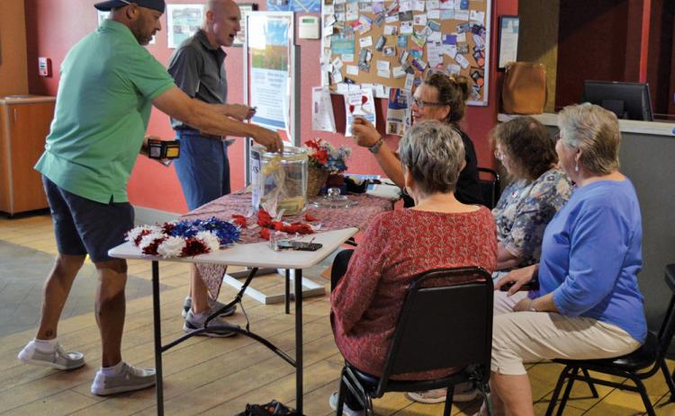 erick mitchell | dispatch record Putters &amp; Gutters guests make donations to the American Legion Auxiliary in honor of National Poppy Day, which was recognized last Friday. Auxiliary volunteers were at the local business to hand out red poppies in memory of America’s fallen heroes.