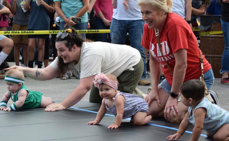 Families from across the county bring their crawlers and toddlers to participate in the Diaper Derby, held on the Lampasas courthouse square. One parent often is stationed at the starting line, while another family member awaits at the finish, coaxing the child across the mat. FILE PHOTO