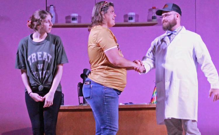 Abigail Stewart, who plays the receptionist in “The Devious Dentist …,” watches as Jennifer Wisian, in the role of nurse, greets Travis Walls, who portrays one of the two dentists in the production. Both Stewart and Wisian are from Lometa, while Walls is a Goldthwaite resident. COURTESY PHOTO