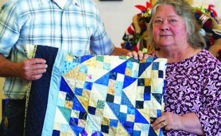 Connie Hamill was named the overall grand champion of the County Fair with this quilt. County Judge Randy Howyer is photographed with her. HUNTER KING | DISPATCH RECORD