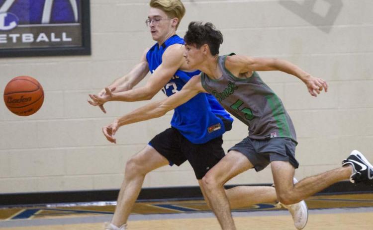 Cort Howard, left, and an opposing player race to the ball near the corner of the court in a recent game. JEFF LOWE | DISPATCH RECORD