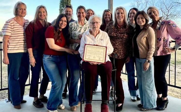 A group of Aggie Moms surrounds Carol Wright as she holds the club’s certificate recognizing its 35th anniversary. Wright was one of the founding members in 1990. COURTESY PHOTO