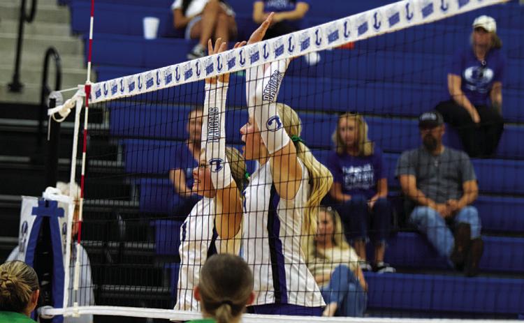 Scout Barton, left, and Brylie Turner jump for a block in their match against Burnet. HUNTER KING | DISPATCH RECORD
