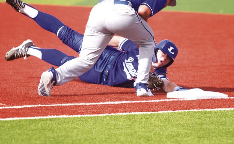 HUNTER KING | DISPATCH RECORD Rawlin Smith dives back into first base after a pickoff attempt during last week’s game.