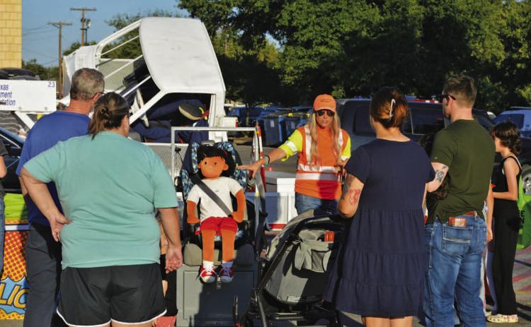 Lampasas residents receive instruction from Texas Department of Transportation staff during Tuesday’s National Night Out on the importance of child safety seat usage and ensuring young passengers are correctly strapped in while riding in a vehicle. ERICK MITCHELL | DISPATCH RECORD