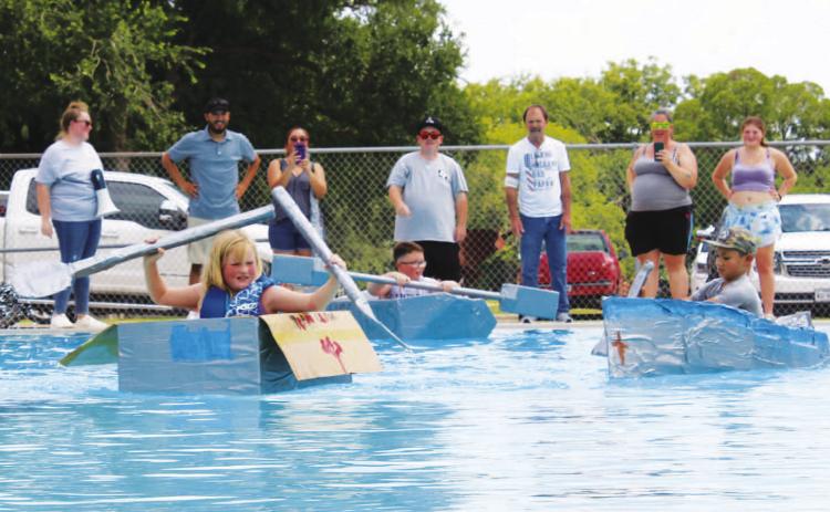 At left, Sarah Wertz takes the lead in the race during Saturday’s Spring Ho Cardboard Regatta. CHLOE COWDREY | DISPATCH RECORD