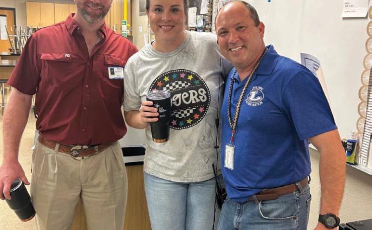 Chandler Hail, center, was selected September Teacher of the Month. Administrators said the science teacher is tough but fun in the classroom, and she continues this love and high standards as a coach on the volleyball and basketball court. Clay Phillips, left, of Texas Farm Bureau Insurance was on hand for the recognition, along with Principal Paul Weinheimer. courtesy photo