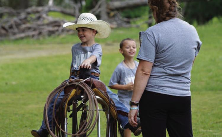 Kyler Harrell embraces his inner cowboy and climbs atop a saddle. ERICK MITCHELL | DISPATCH RECORD