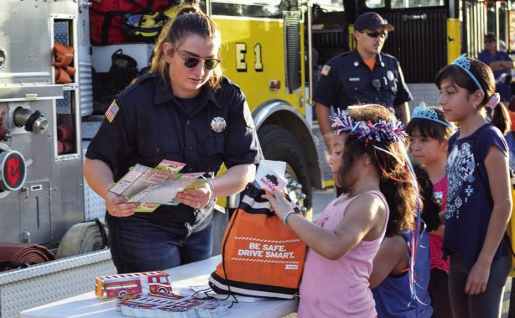 After having to cancel the local observation of National Night Out last year, law enforcement agencies and officials will stage the community engagement event again this year. Booths with giveaways will be set up, as is pictured here, and food and activities will be offered. FILE PHOTO