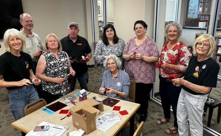 Members of The Stars at Night committee are preparing flashlights for distribution to children at Saturday evening’s event. COURTESY PHOTO