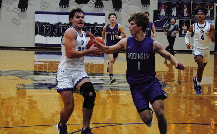 Carter Johnson drives past a defender for a layup in the Badgers’ home game. HUNTER KING | DISPATCH RECORD
