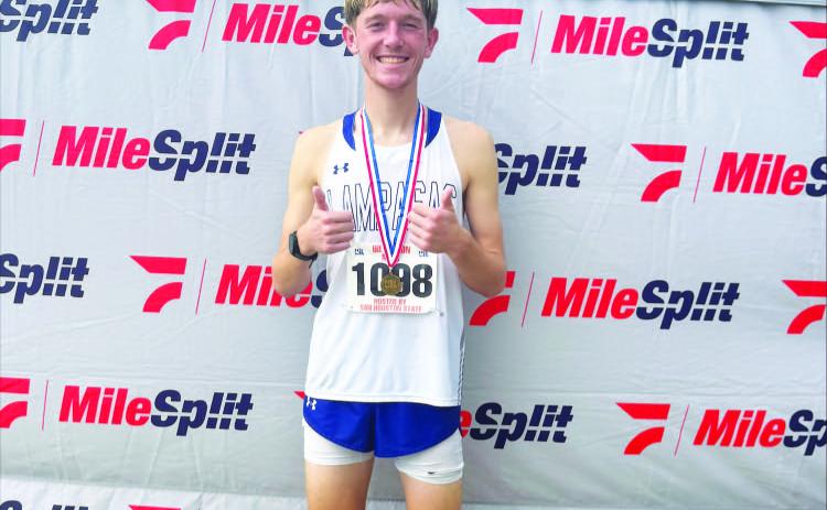 COURTESY PHOTO | KIM BURNSIDE John Keyes poses with his medal after finishing 10th at the regional cross country meet and qualifying for state.