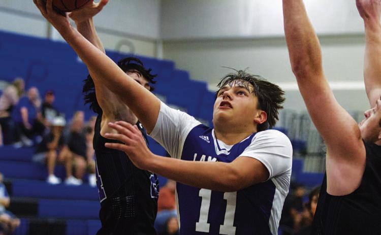 Dylan Polmanteer cuts through two Richland Springs defenders for a layup. HUNTER KING | DISPATCH RECORD