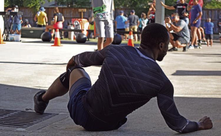 An athlete stretches in preparation for a competition outside of Houston. The assumption that daily exercise is the only requirement for an athlete negates the invisible percentage of work and effort such a lifestyle requires, including nutrition, programming, routine and rest. ALEXANDRIA RANDOLPH | DISPATCH RECORD