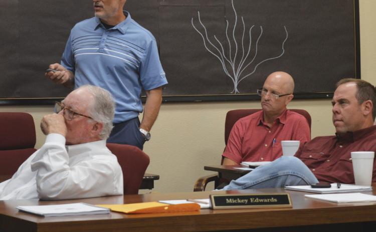Lampasas ISD Assistant Superintendent Dana Holcomb, standing, discusses 2025 STAAR scores during Monday’s Board of Trustees meeting. Trustees also reviewed preliminary budget numbers for fiscal year 2025-2026 with Chief Financial Officer Shane Jones, seated at back. In foreground are board members Mickey Edwards, at left, and Board President Ryan Shahan. erick mitchell | dispatch record