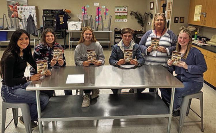 Judy Hail, standing at right, and some of her students display the “Hank the Cowdog” books given to the LISD agriscience program. COURTESY PHOTO