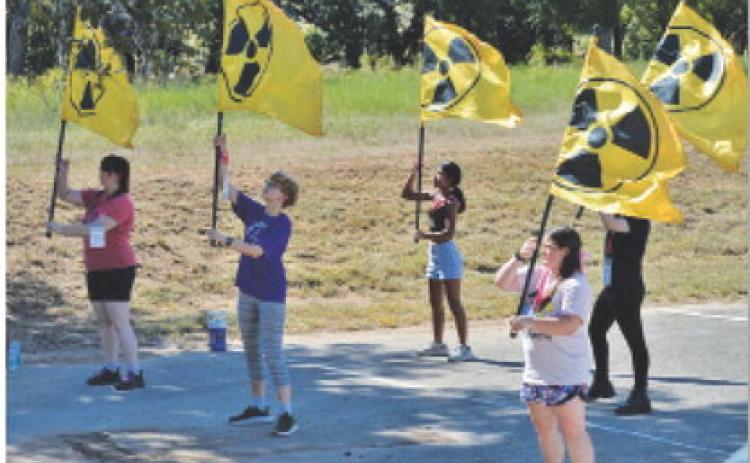 LHS color guard members wave flags with the nuclear symbol, an ode to the nuclear blasts that take place in the “Fallout” universe. ERICK MITCHELL | DISPATCH RECORD