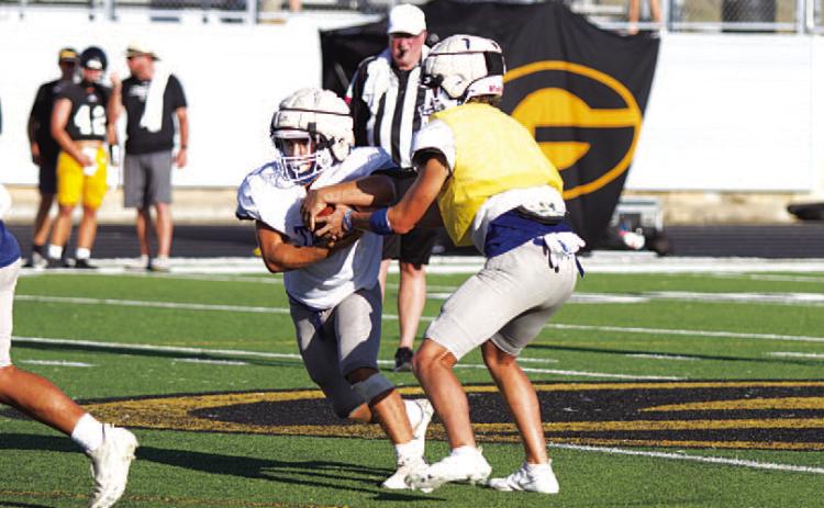 FILE PHOTO Bryson Roberts hands the ball to Daemian Rivas at the Badgers’ first scrimmage last week.