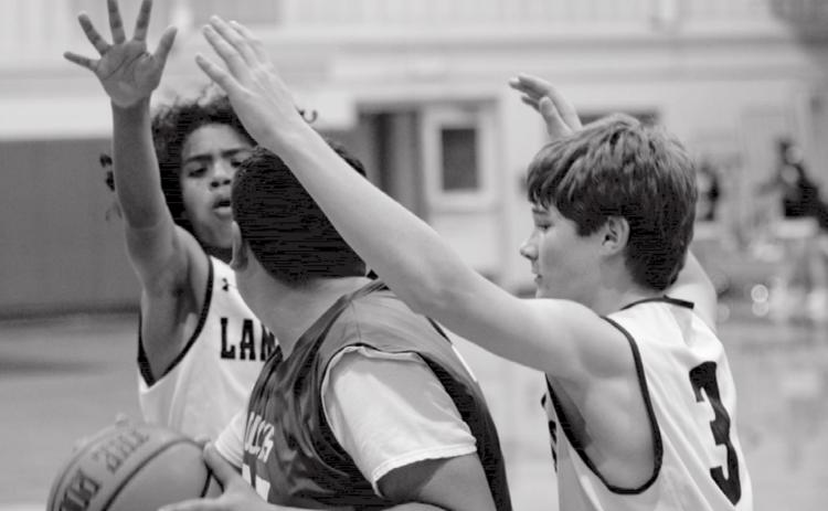 Angel Scott, back left, and Timber Gholson (3) trap a Taylor Duck in the Badgers’ eighth-grade “B” victory at home Thursday. JEFF LOWE | DISPATCH RECORD