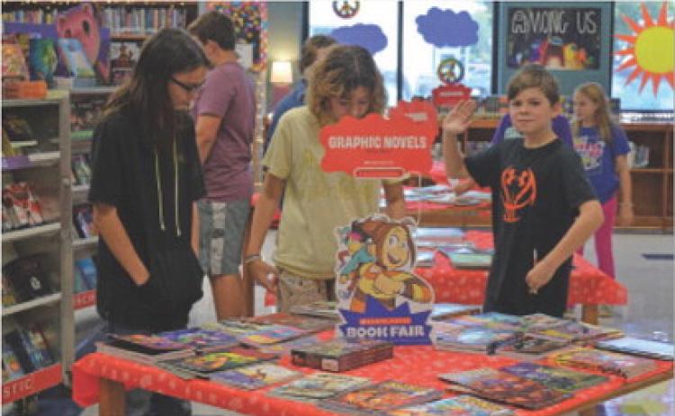 Seventh-grade students in Jennifer Baker’s class scan a display for books that may interest them at Lampasas Middle School’s Scholastic Book Fair. erick mitchell | dispatch record