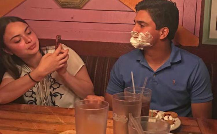 In 2018, after Erick Mitchell’s parents told the Magic Time Machine server it was his birthday, crew members serenaded him before covering his face in whipped cream. Mitchell’s wife, Emma, tries to capitalize on the moment with a photograph. courtesy photo
