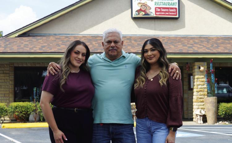 Alfredo Suarez stands with daughters Arleny, left, and Valeria outside his restaurant on U.S. Highway 281 South. The family-owned business takes pride in treating customers like they are special kinfolk, too. The Mexican restaurant will host a twoday celebration next week in honor of its 20 years of operation in Lampasas. ERICK MITCHELL | DISPATCH RECORD