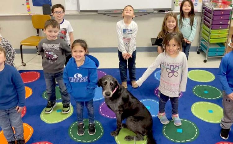 Students from Lexi Simpson’s pre-Kindergarten class pose with Happy, the Hanna Springs Elementary School campus dog. COURTESY PHOTO