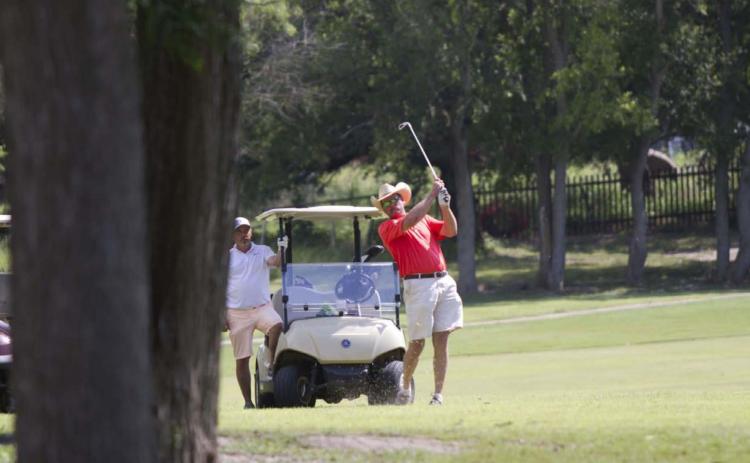 Warren Thornton follows through on a shot on Hole No. 5 during the afternoon tournament benefiting the high school golf program. HUNTER KING | DISPATCH RECORD
