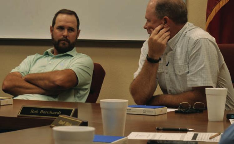 Trustees Ryan Shahan, left, and Rob Borchardt discuss options for a Lampasas ISD bond election that could go before voters in May. ERICK MITCHELL | DISPATCH RECORD