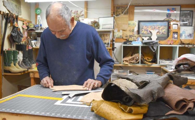 Lampasas bootmaker Pablo Jass measures a piece of leather as he cuts it into a vamp. MADELEINE MILLER | DISPATCH RECORD