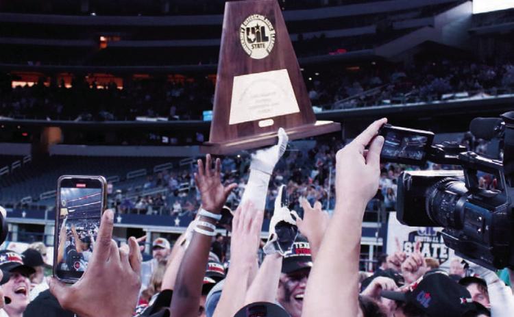 The state championship trophy is lifted high by a victor from 2022. FILE PHOTO