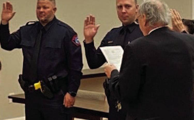 Lampasas Municipal Judge Robert Gradel administers the oath of office to incoming police officers Jacob Loeve and Jeff Phillips. COURTESY PHOTO
