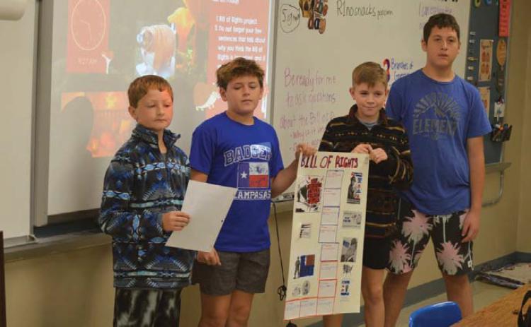 From left are students Kash Kreider, Shade Clouds, Trigg Hill and Bentley Larsen as they present their Bill of Rights poster during class on Wednesday. Erick Mitchell | Dispatch Record